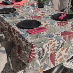 Photo d'ambiance nappe sur table Lombok, Citrouille : feuillage aux nuances de rouge, de orange et de beige sur un fond beige, feuillage avec des contours noirs