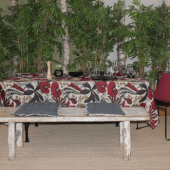 Photo d'ambiance nappe sur table Lombok, Burnt Russet : feuillage aux nuances de mauve, de rouge et de jaune sur un fond beige, feuillage avec des contours noirs