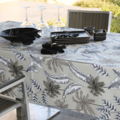Photo d'ambiance nappe sur table Jungle, Taupe : feuillage aux nuances blanches et palmiers noir et beige.