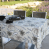 Photo d'ambiance nappe sur table Jungle, Taupe : feuillage aux nuances blanches et palmiers noir et beige.